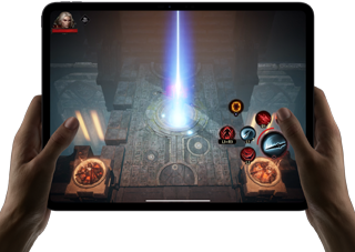 Two hands holding iPad Pro, displaying game with on screen touch controls and advanced graphics